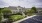 Apartment leasing building exterior with greenery and parking spaces
