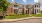 a large brick building with a lawn and trees in front